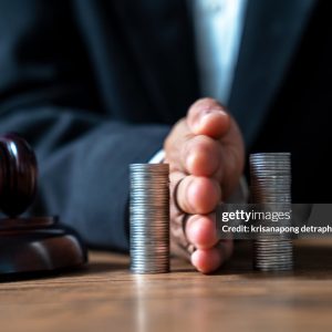 Concept of saving money and investment growth. Lawyer's hand holding coins on a pile of coins. Division of assets.,Concept of saving and investing.